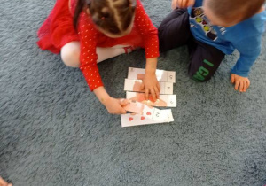 Dwoje dzieci układa misiowe puzzle z pięciu części.
